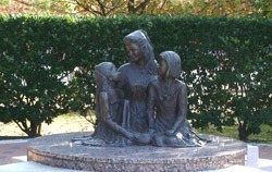 Stone monument of a woman and 2 children. 